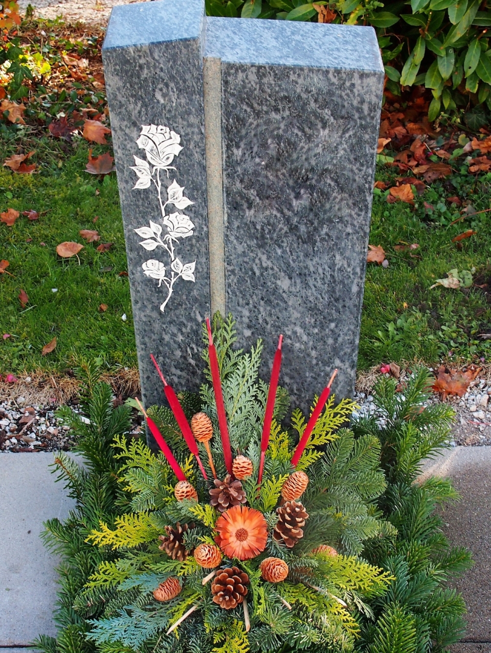 墓地玫瑰雕刻石碑前植物蜡烛