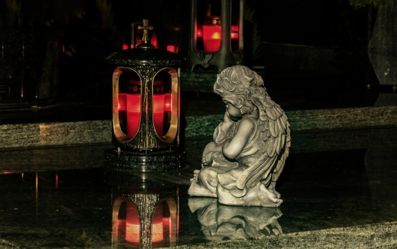 夜晚公墓灯笼旁白色天使雕像