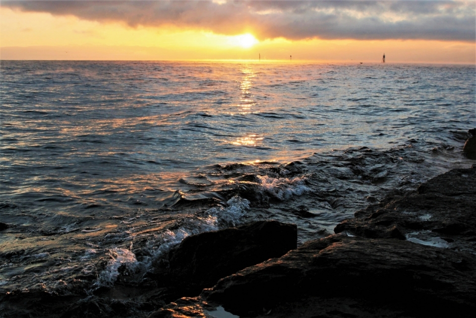 夕阳下站在大海边礁石上的美丽风景
