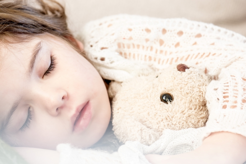 抱着玩具熊睡着的女孩脸部特写