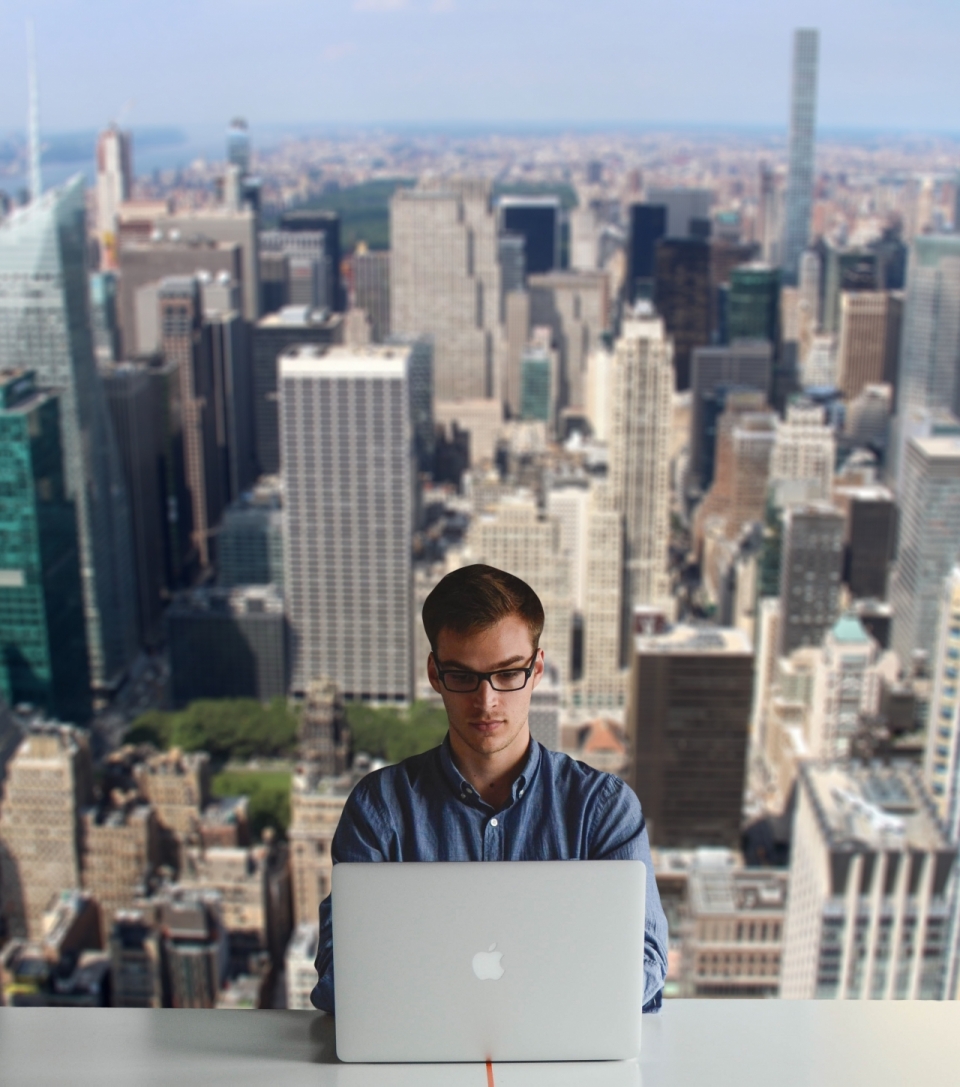 人物摄影_城市背景戴眼镜男性用笔记本电脑工作