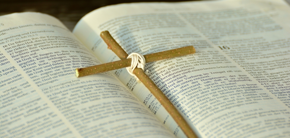 英文书本上放着木头做的十字架