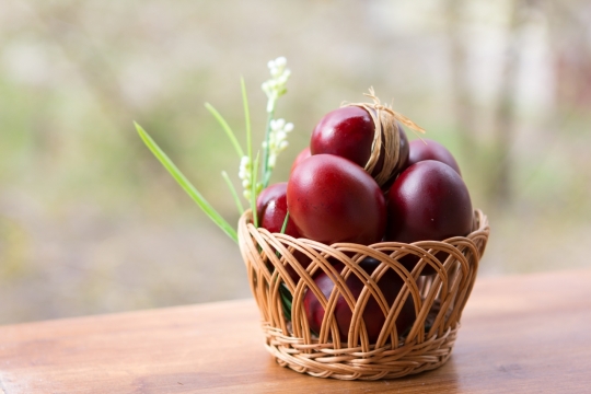 虚化背景木制桌面竹篮红色新鲜彩蛋