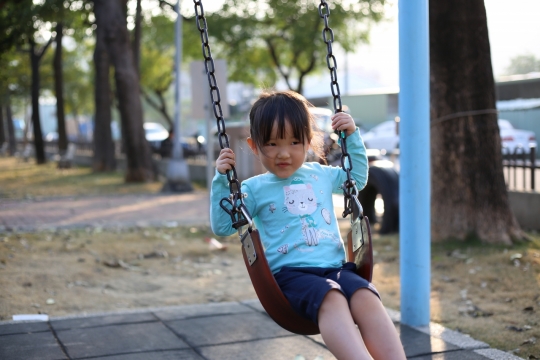 阳光城市街道公园荡秋千女孩