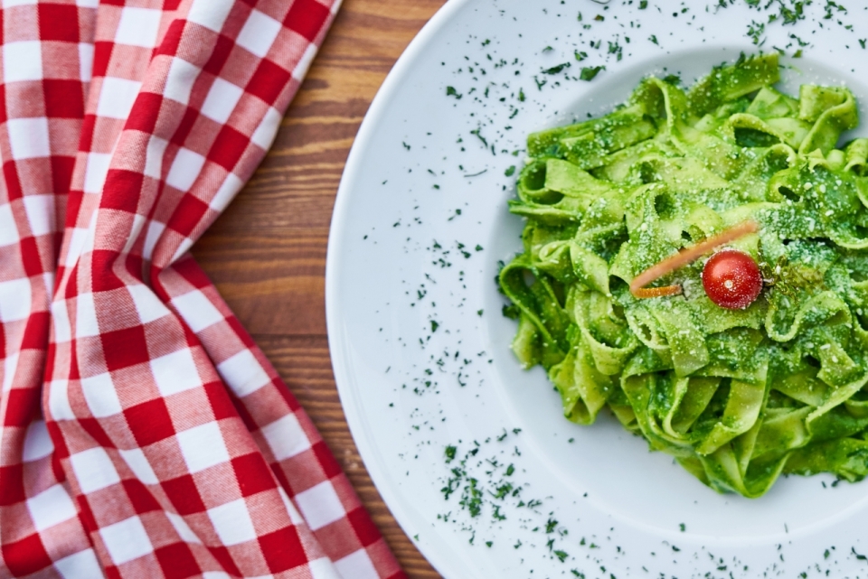 餐桌上盘子里绿色健康蔬菜面条摄影