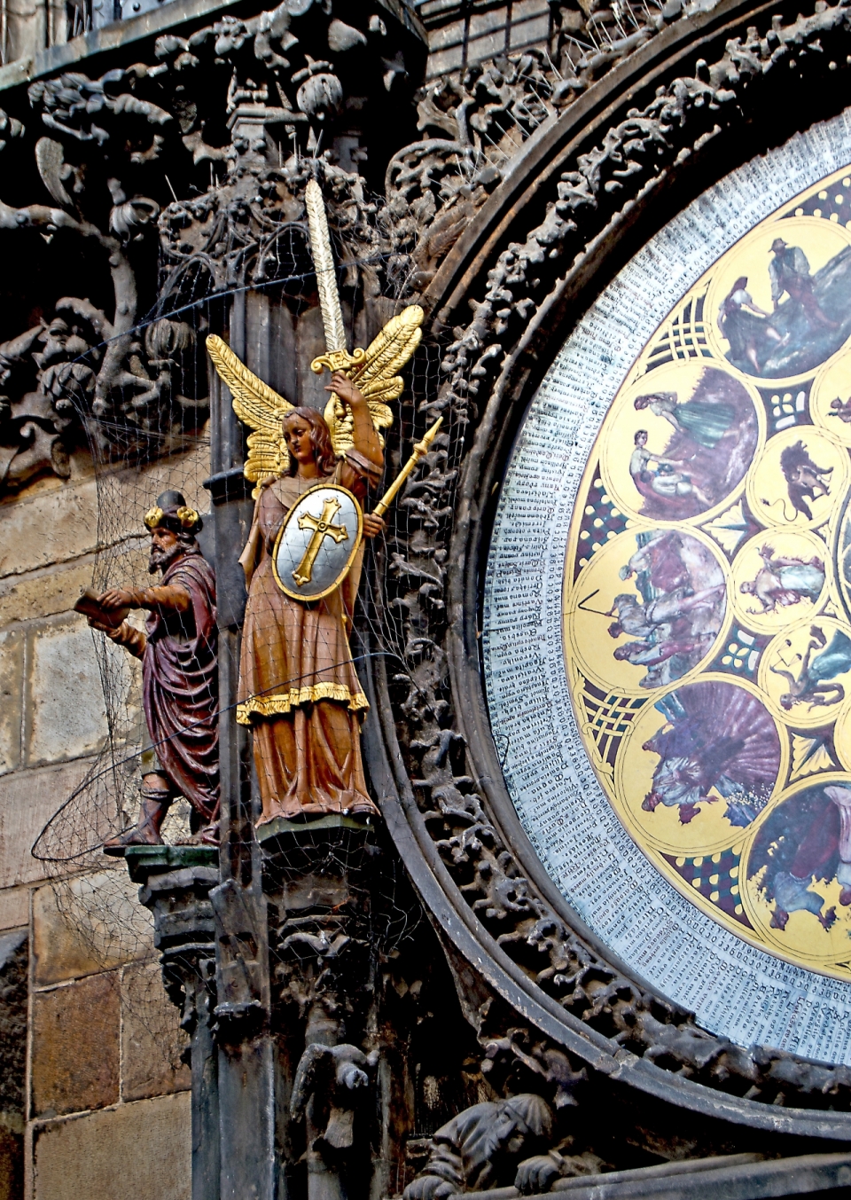 古老城镇巨大时钟旁彩色塑像
