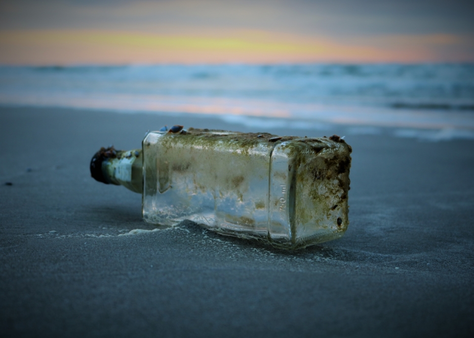 虚化背景傍晚沙滩边污渍玻璃瓶子