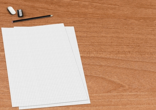 木桌上的铅笔橡皮和方格纸背景素材